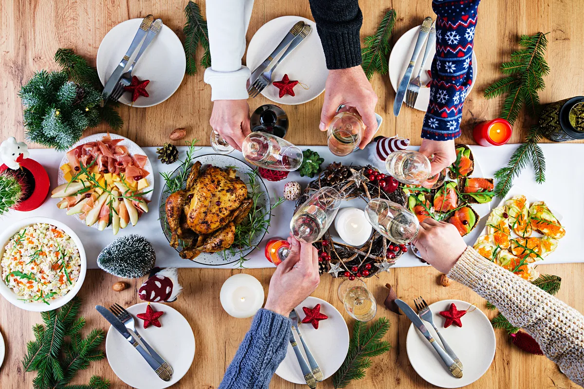 baked-turkey-christmas-dinner-christmas-table-is-served-with-turkey-decorated-with-bright-tinsel-candles-fried-chicken-table-family-dinner-top-view-hands-frame.jpg