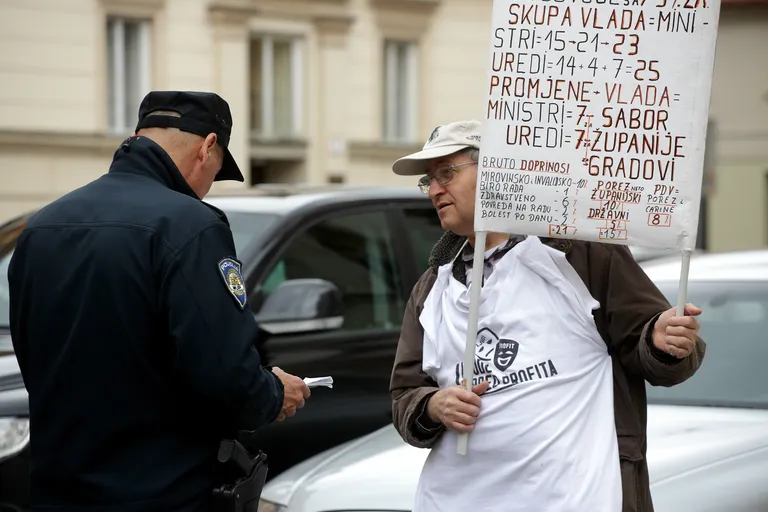 Policajac provjerava identitet prosvjednika na markovom trgu