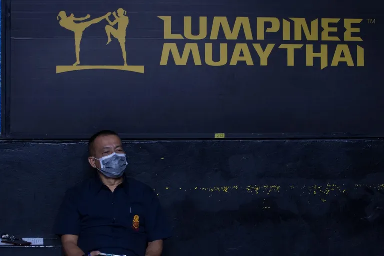 A referee wearing a face mask during the Thai Boxing match that was held without spectators as a preventive measure against the spread of COVID-19 coronavirus at Lumpinee Boxing Stadium.